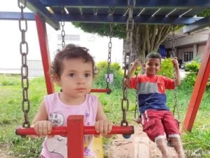 menino e menina-brincando-no-balanco-do-playground